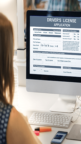 A person looking at a driver's license issuance monitor
